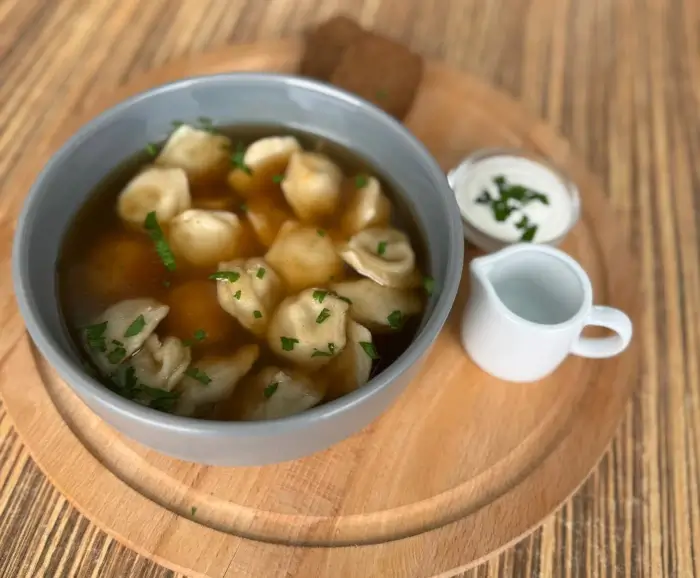 Pelmeņi ar stirnas gaļu aromātiskā buljonā ar krējumu